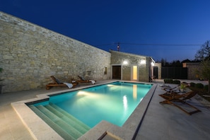 A swimming pool with stone walls and lounge chairs. - Villa Granar Zadarvillas (Benkovac)