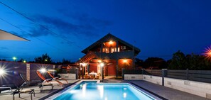 A modern house with a swimming pool, outdoor seating, and a well-lit patio area. - Villa Chervil Zadarvillas (Benkovac)