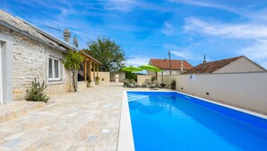 A swimming pool with a stone patio, a covered seating area, and a stone building. - Villa Outback Zadarvillas (Benkovac)