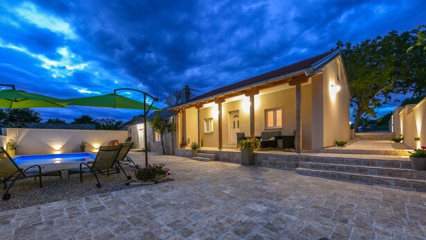 A patio area with a pool, outdoor seating, and a covered porch. - Villa Outback Zadarvillas (Benkovac)