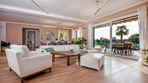 Una sala de estar amplia con un conjunto de sofás, una mesa de centro y un comedor con una mesa y sillas.