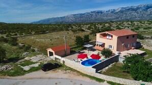 A two-story house with a swimming pool, a car parked in front, and mountains in the background. - Villa Nea Zadarvillas (Posedarje)