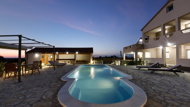 A swimming pool with lounge chairs and a covered seating area. - Villa Roko Zadarvillas (Škabrnja)
