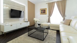 A modern living room with a flat-screen TV, white sofa, and a coffee table. - Villa Bella Zadarvillas (Novigrad)