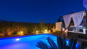 A swimming pool with a blue hue, surrounded by potted plants and a white gazebo. - Villa Bella Zadarvillas (Novigrad)