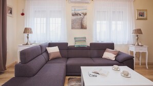 A living room with a large sectional sofa, a coffee table with books and cups, and two side tables with lamps. - Villa Olive Zadarvillas (Policnik)