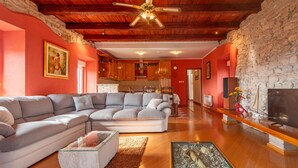 Una sala de estar con sofá modular, una mesa de centro de vidrio y una chimenea.