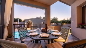 An outdoor dining area with a pool view, tables set with plates and glasses, and chairs. - Villa Antea Zadarvillas (Zadar)