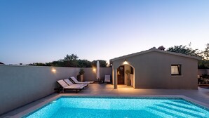 A rooftop swimming pool with lounge chairs and a small building with a door and lights. - Villa Antea Zadarvillas (Zadar)