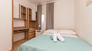 Ein Schlafzimmer mit einem Bett, einem Nachttisch, einem Spiegel und einem Kleiderschrank.
