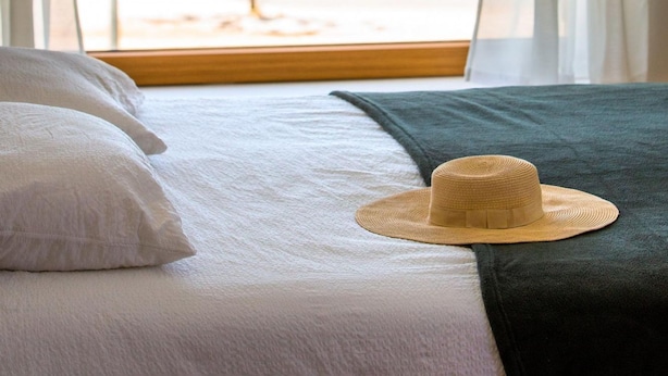 A bed with a view of a lake through a window with curtains. - Villa Roberta Zadarvillas (Sveti Filip i Jakov)