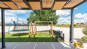 A covered outdoor area with a trampoline, swing set, and artificial turf. - Villa Descansa in Dracevac Ninski (Nin)