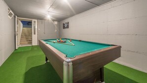 A pool table in a room with a green carpet, white walls, and a staircase leading to an upper level. - Villa Tara Zadarvillas (Benkovac)
