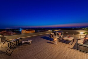 A rooftop terrace with lounge chairs, a table, and a decorative lamp. - Villa Tia Zadarvillas (Policnik)