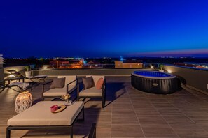 A rooftop terrace with outdoor seating, a hot tub, and a view of the city at dusk. - Villa Tia Zadarvillas (Policnik)