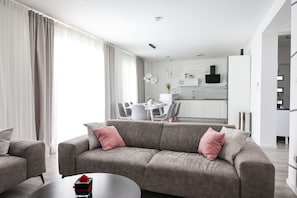 A modern living room with a grey sofa, a coffee table, and a dining area in the background. - Villa Tia Zadarvillas (Policnik)