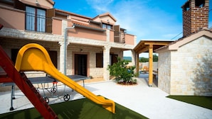 A courtyard with a children's play area, including a slide and a table tennis table. - Villa Kamen Zadarvillas (Novigrad)