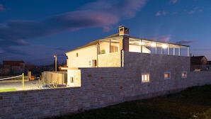 A modern house with a stone facade, a glass extension, and a visible chimney. - Villa Kamen Zadarvillas (Novigrad)