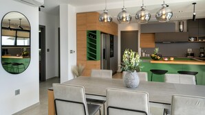A modern kitchen with a central island, green cabinetry, and pendant lighting. - Villa Oasis Zadarvillas (Zadar)