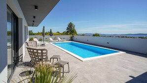 A rooftop swimming pool with lounge chairs and a view of the landscape. - Villa Oasis Zadarvillas (Zadar)