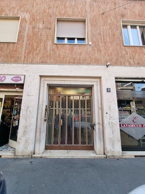 A building with a large glass door entrance, a brick facade, and a storefront with a sign that reads 'LAVASECCO &'.