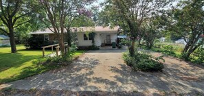 A single-story house with a front porch, a driveway, and a well-maintained lawn. - Cozy 3 bedroom 2 bath residential home with patio (Antlers)