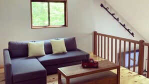 Uma sala de estar com sofá, mesa de centro e escada.