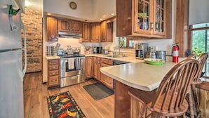Una cocina con armarios de madera, electrodomésticos de acero inoxidable y una isla grande con sillas.