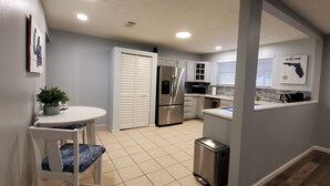A modern kitchen with a white countertop, stainless steel appliances, and a tiled floor. - Beach house 3BR/3.5BA 5 minute walk to bay with extra parking for a boat/RV (Navarre)