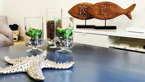 Ett bord med tre glasterrarium som innehåller växter, en träskulptur föreställande en fisk och en dekoration i form av en sjöstjärna.