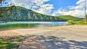 A lakeside view with a sandy beach and a forested hill in the background. - Table Rock Lake Hideaway w/ Deck: Bring Your Boat! (Golden)