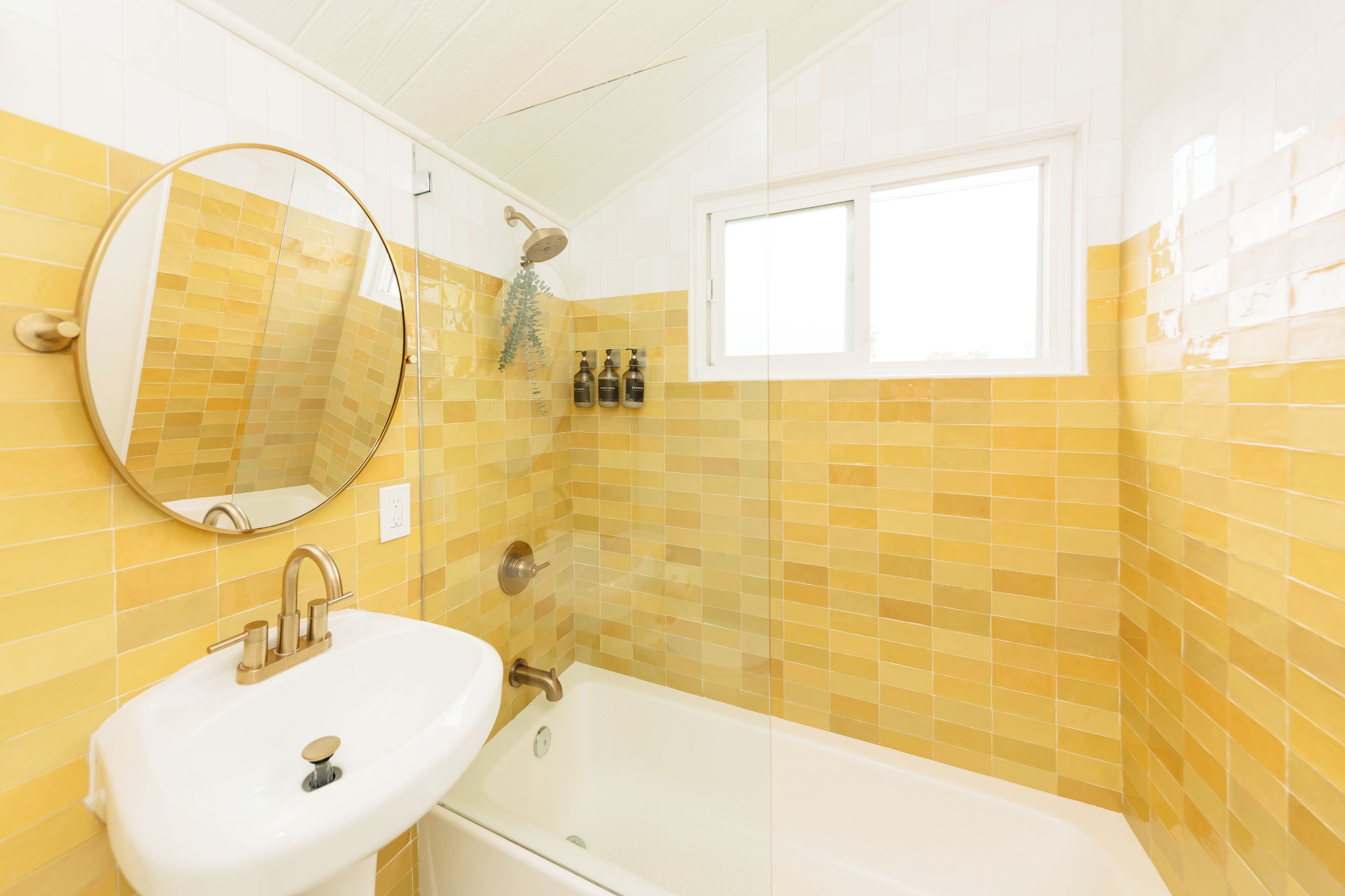 Ein Badezimmer mit Waschbecken, Spiegel und Badewanne.