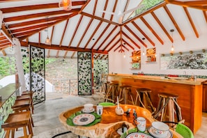A rustic interior with wooden beams, a bar area, and a dining setup with traditional decor.