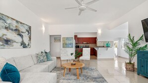 Ein modernes Wohnzimmer mit einem grauen Sofa, einem Couchtisch und einem Deckenventilator.