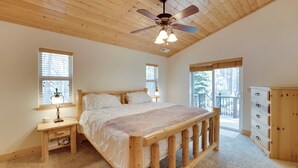 Ein Schlafzimmer mit einem Holzbett, einem Nachttisch, einer Kommode und einem Deckenventilator.