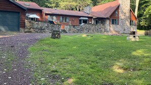 A rustic cabin with a stone chimney, wooden siding, and a stone wall. - Spacious Lake Harmony Rustic Home. Month & Seasonal rates (Split rock, Lake Harmony)