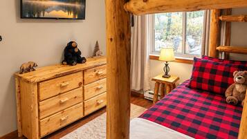 Cozy rustic bunk room with log beds and charming cabin-style decor