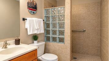 A bathroom with a toilet, sink, and shower.