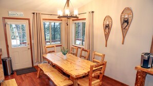 A wooden dining table with benches, a coffee maker on a wooden stand, and a welcome sign on the door. - Cozy pet-friendly home near hiking trails and Lake Vermilion (Tower)