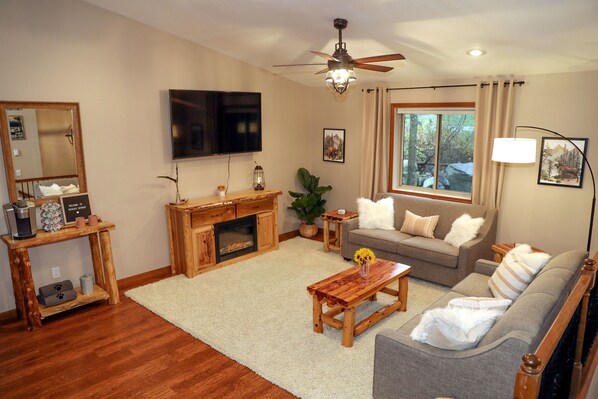 A living room with a fireplace, a sofa, a coffee table, and a television.