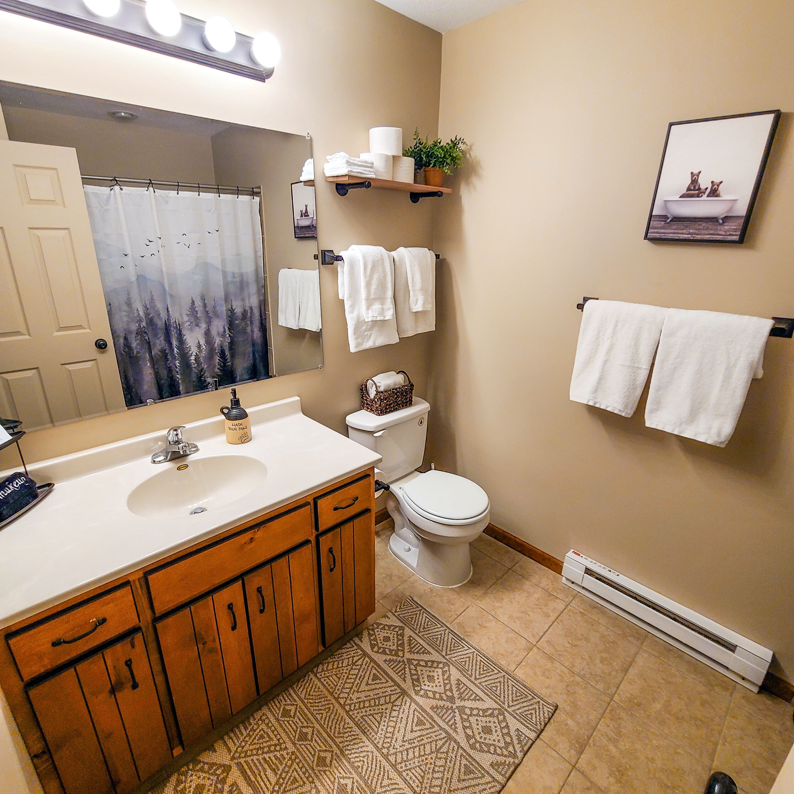 Een bad/douchecombinatie, een haardroger, handdoeken, zeep