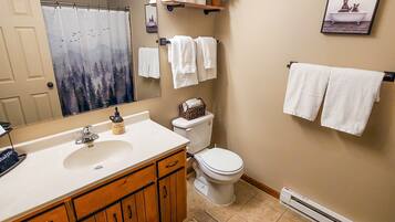 Een bad/douchecombinatie, een haardroger, handdoeken, zeep