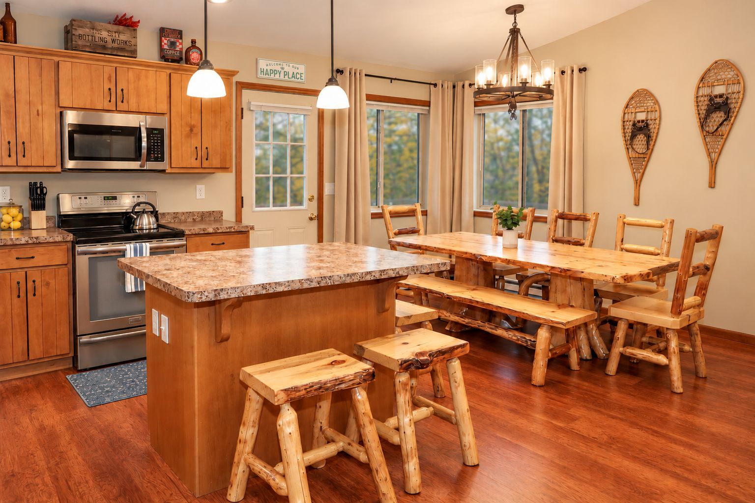 Rustic kitchen and dining area with log furniture and scenic woodland views
