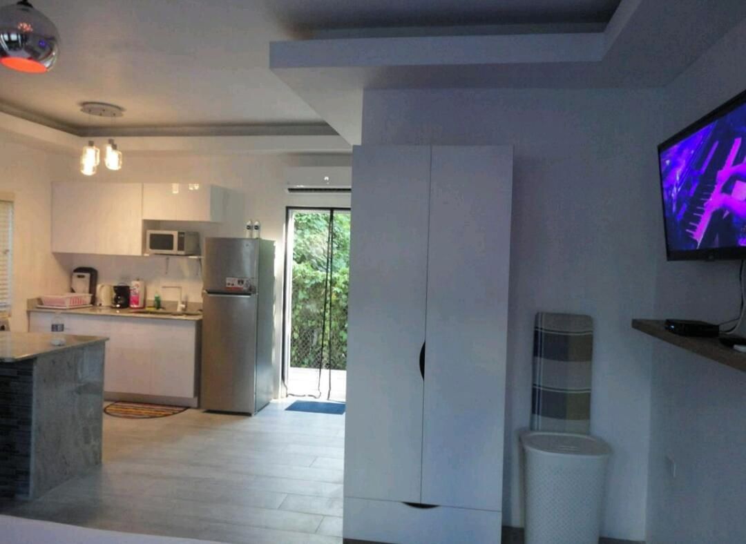 Una cocina moderna con microondas integrado, refrigerador y un ventanal grande.