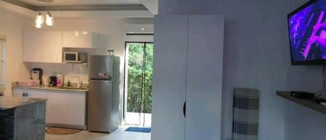 Una cocina moderna con microondas integrado, refrigerador y un ventanal grande.