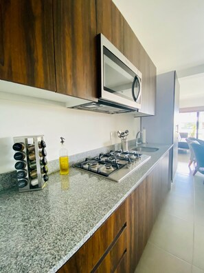 Réfrigérateur, four à micro-ondes, surface de cuisson, cafetière-théière