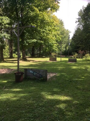 Relax in a serene outdoor space surrounded by mature trees and a well-maintained lawn.