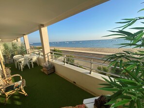 A balcony with a view of the sea, white plastic chairs, and potted plants. - Beautiful apartment with magnificent sea view (Arcachon)