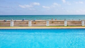 Una piscina con vista sull'oceano e sulla spiaggia.
