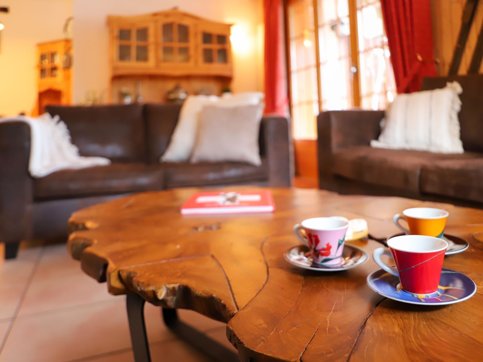 Ein gemütliches Wohnzimmer mit Couchtisch, zwei Sofas und einem Bücherregal im Hintergrund.